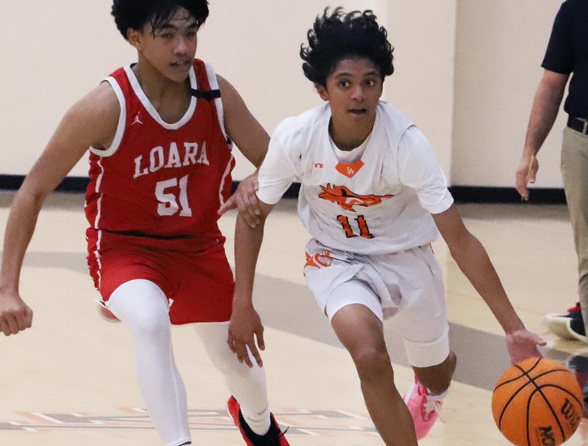 Los Amigos point guard Marc Basallo (11) dribbles past Loara's Justin Camacho (51) during Friday night's game.