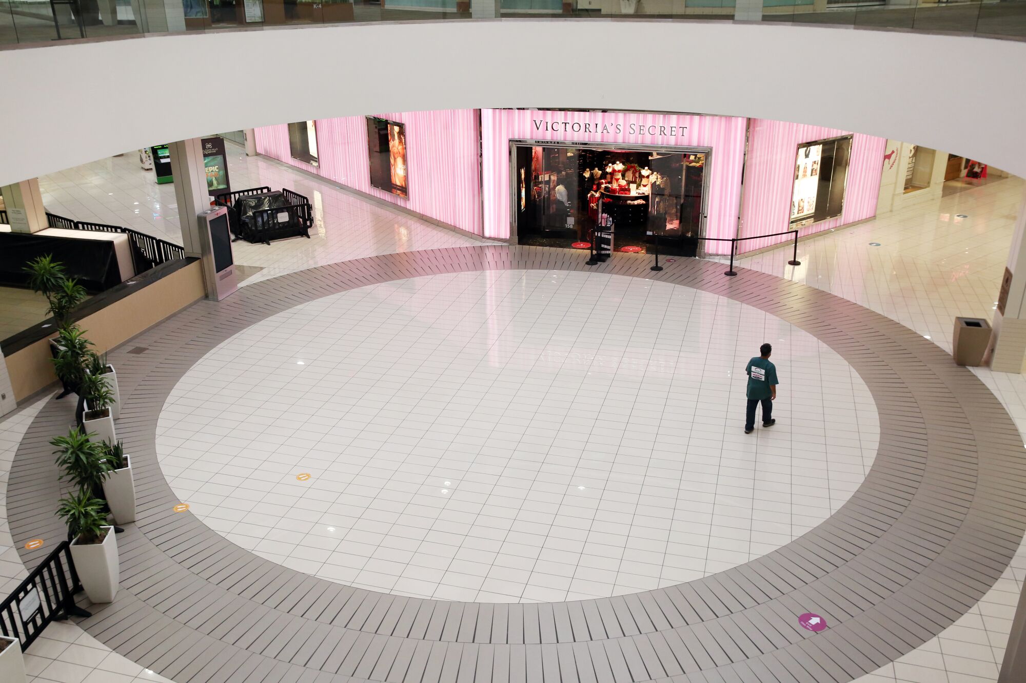 A shopper walks across a circular space on the ground floor of Baldwin Hills Crenshaw Plaza.