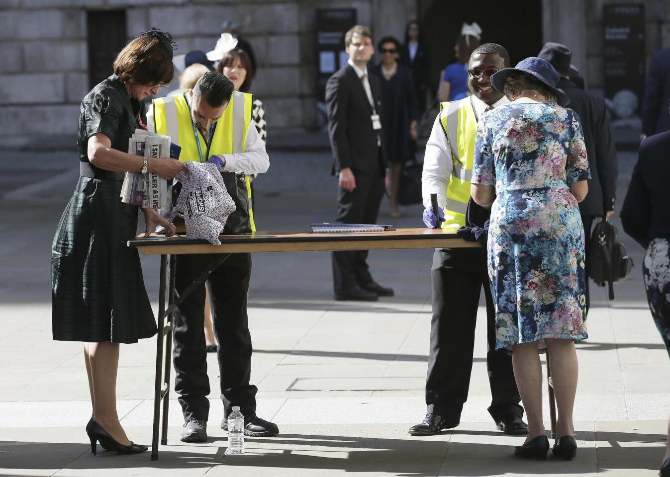 People have their bags searched outside St Paul's Cathedral in London on May 24, 2017, ahead of a service to mark the 100th anniversary of the Order of the British Empire. Amed troops were at vital locations after the official threat level was raised following a suicide bombing in Manchester that killed 22 people.