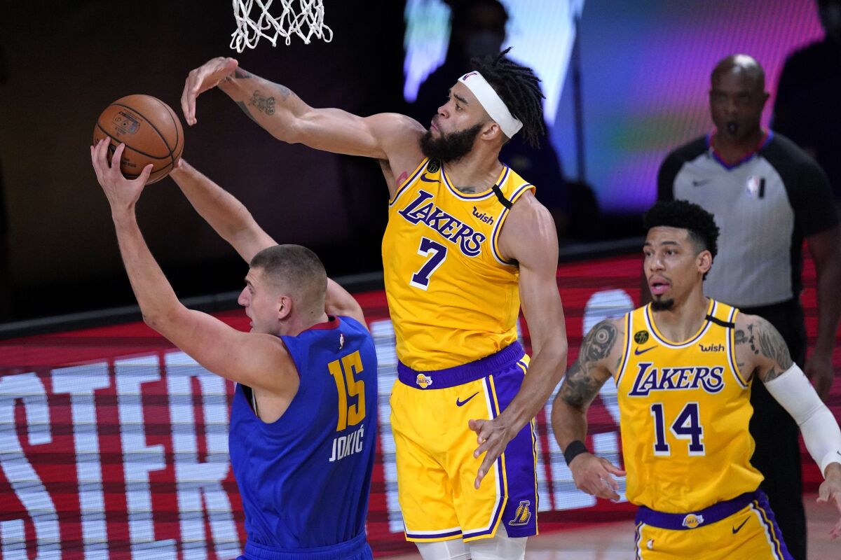 Denver Nuggets center Nikola Jokic (15) comes down with a rebound in front of Los Angeles Lakers' JaVale McGee.