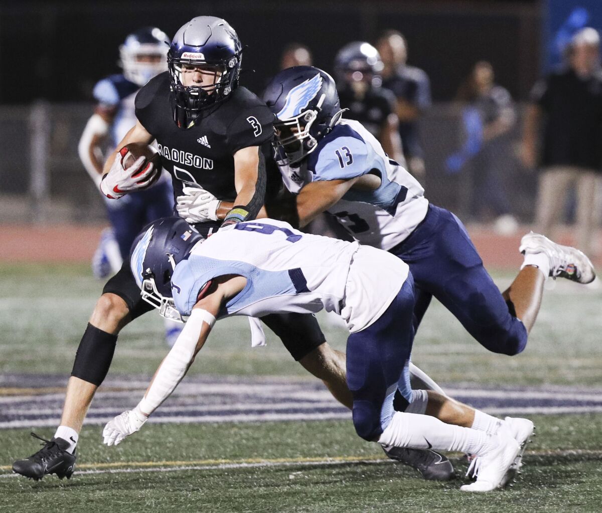 Madison's Jake Jackson (3) is taken down by Granite Hills' Easton Peterson (9) and Nokoi Maddox (13) during Friday's game.