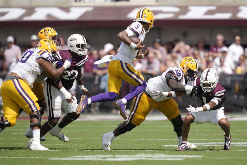 LSU quarterback Jayden Daniels (5) leaps into the air as he attempts to avoid a tackle by Mississippi State defenders during the first half of an NCAA college football game, Saturday, Sept. 16, 2023, in Starkville, Miss. (AP Photo/Rogelio V. Solis)