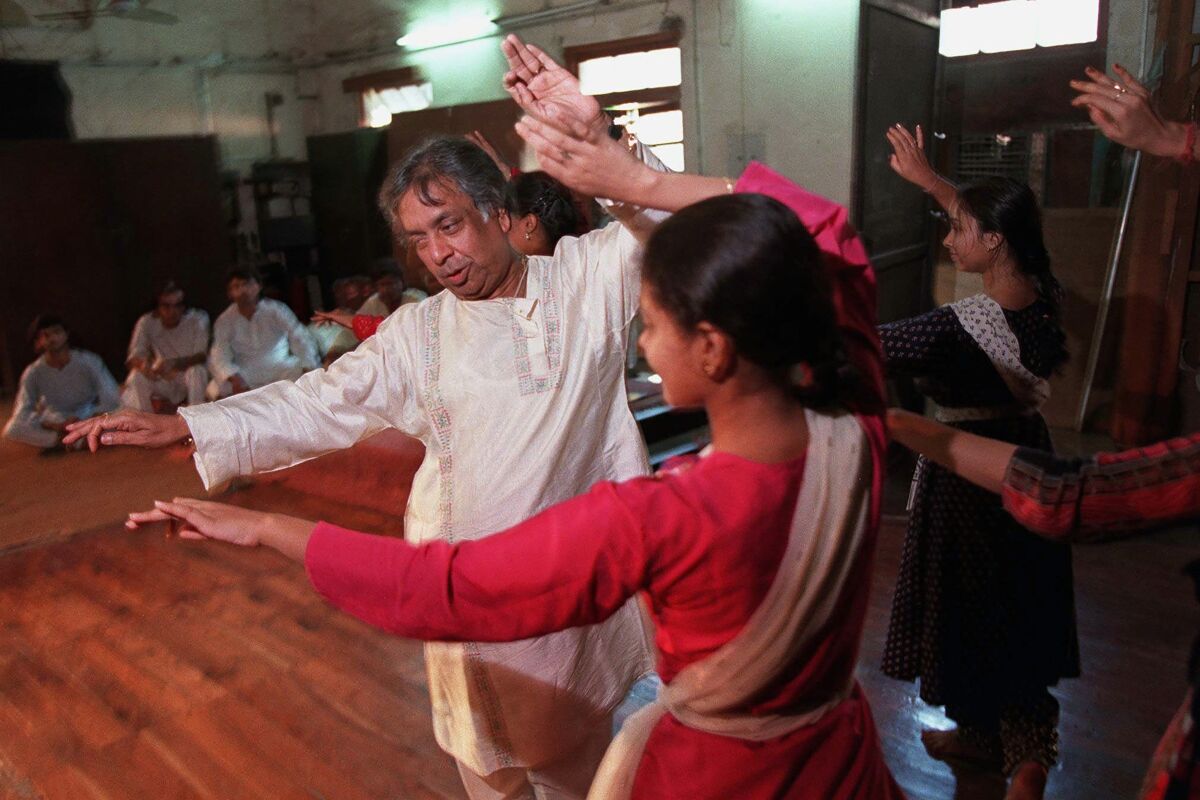 FILE - Indian classical Kathak dance guru Birju Maharaj teaches students at his studio in New Delhi on Sept. 26, 1997. Birju Maharaj, a legend of classical Indian dance and among the country’s most well-known performing artists, died early on Monday, Jan. 17, 2022. He was 83. (AP Photo/John Moore, File)