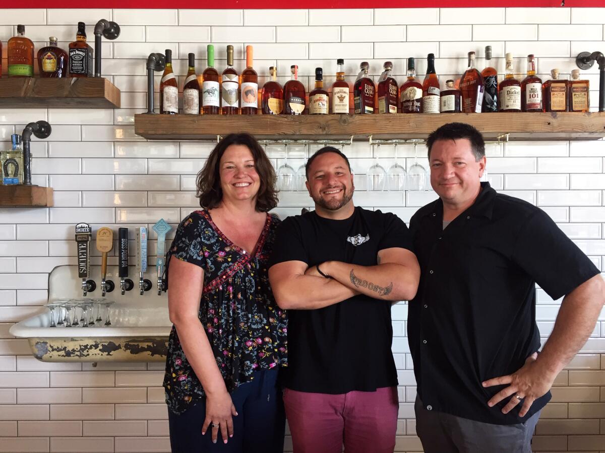 Bantam's Roost Public House partners Aaron Browning, left, her husband Roger "Roddy" Browning, right, and Alex Kleinman, center, whose devotion to the new pub can be seen in the tattoo on his left forearm.