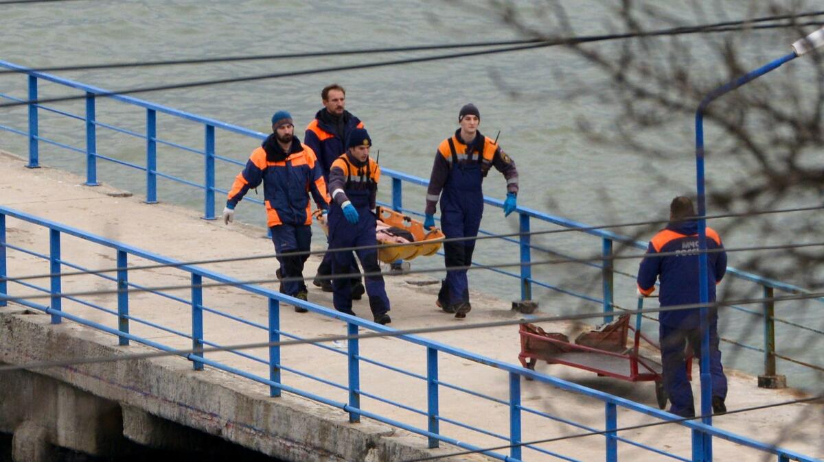 Russian rescue workers carry a body from the wreckage of the crashed plane, at a pier just outside Sochi, Russia, on Dec. 25, 2016.