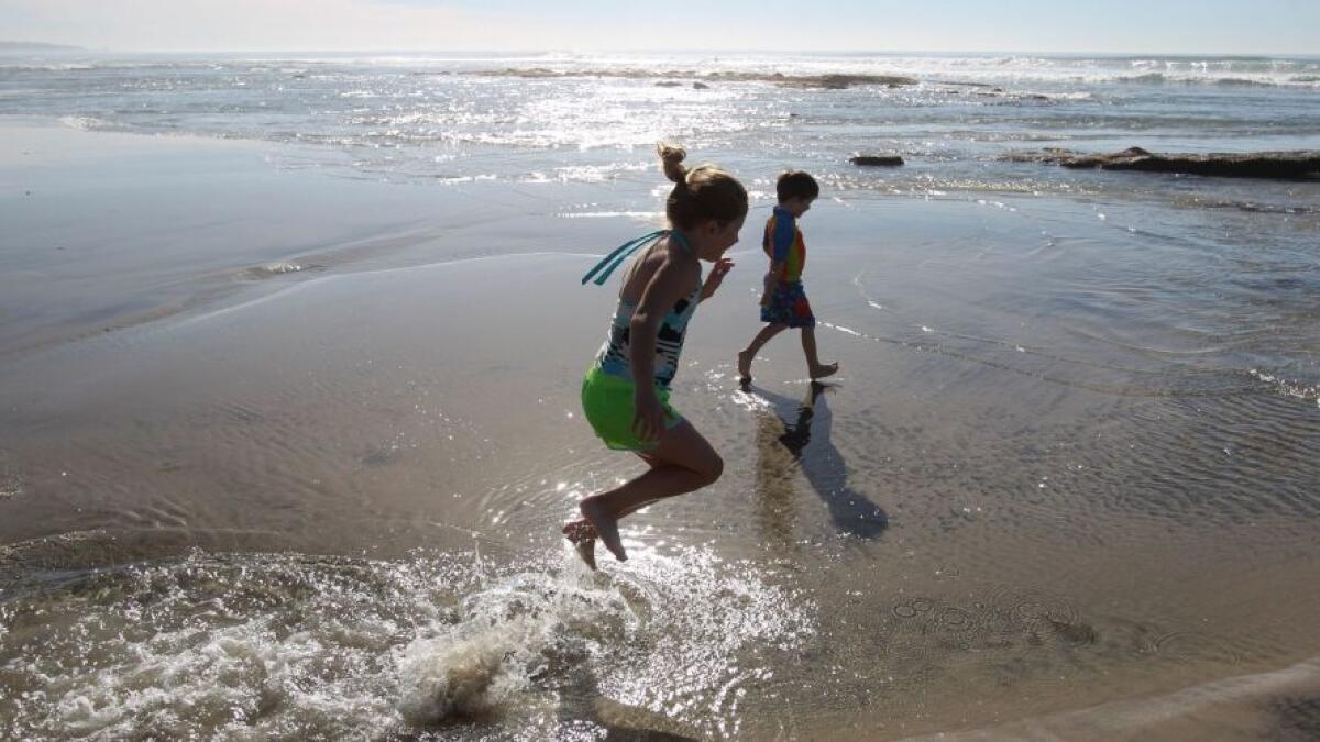 Kids play in puddles left by a low tide in Solana Beach.