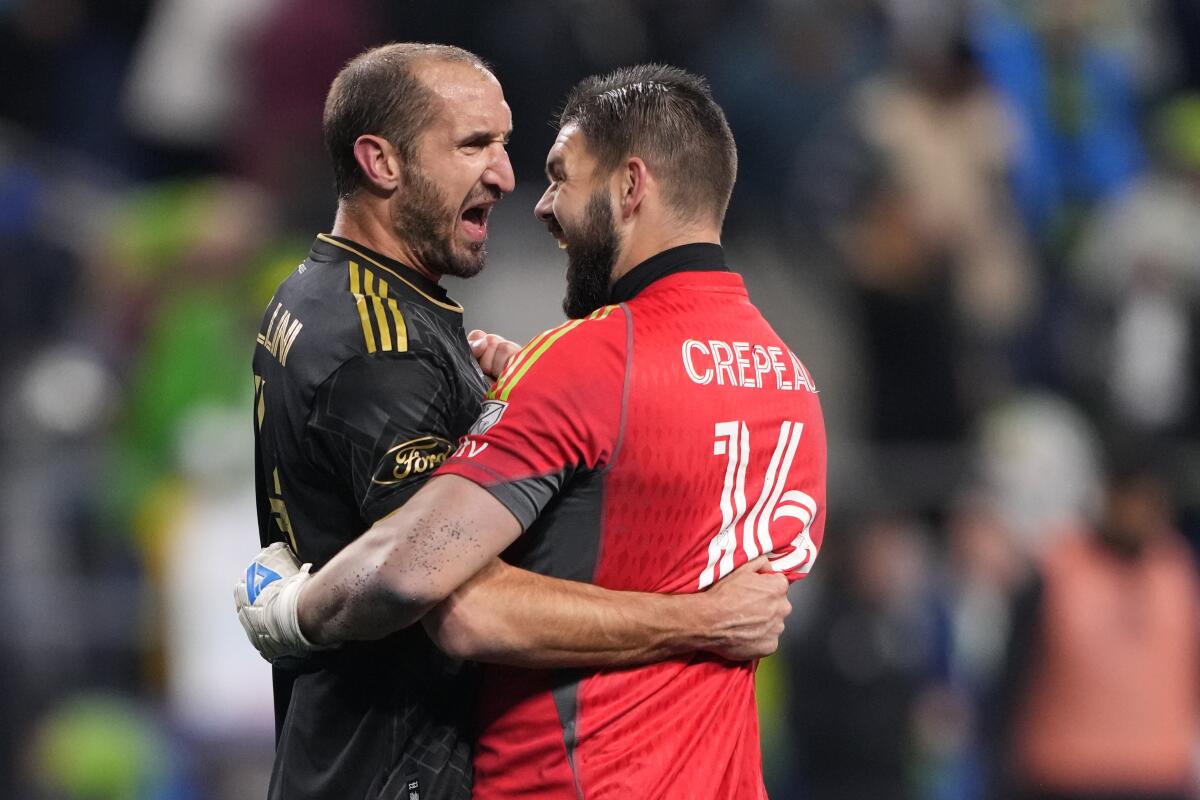 LAFC goalkeeper Maxim Crepeau, right, and defender Giorgio Chiellini embrace after a 1-0 playoff victory over the Sounders.
