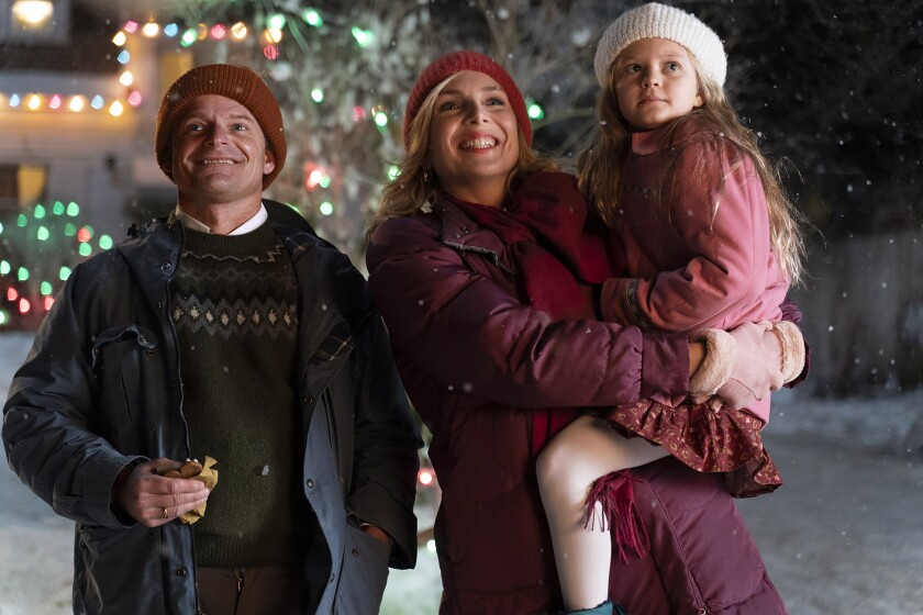 A man, a woman and a child in a snowy landscape at Christmastime