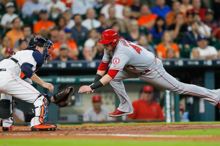 Angels' Jett Bandy slides around the tag of Houston Astros catcher Jason Castro to score in the third inning on Wednesday.