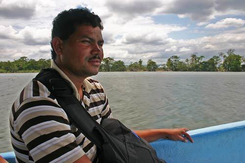 A migrant from Honduras prepares to cross illegally into Mexico, traveling on a speedboat along Guatemala's San Pedro River, one of several busy smuggling routes along the frontier.