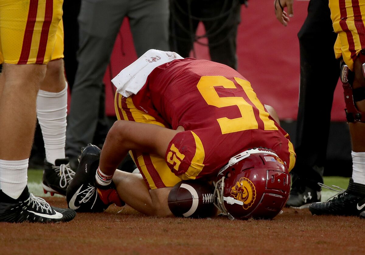 USC receiver Drake London grabs his ankle after getting injured on a touchdown play against Arizona in October.