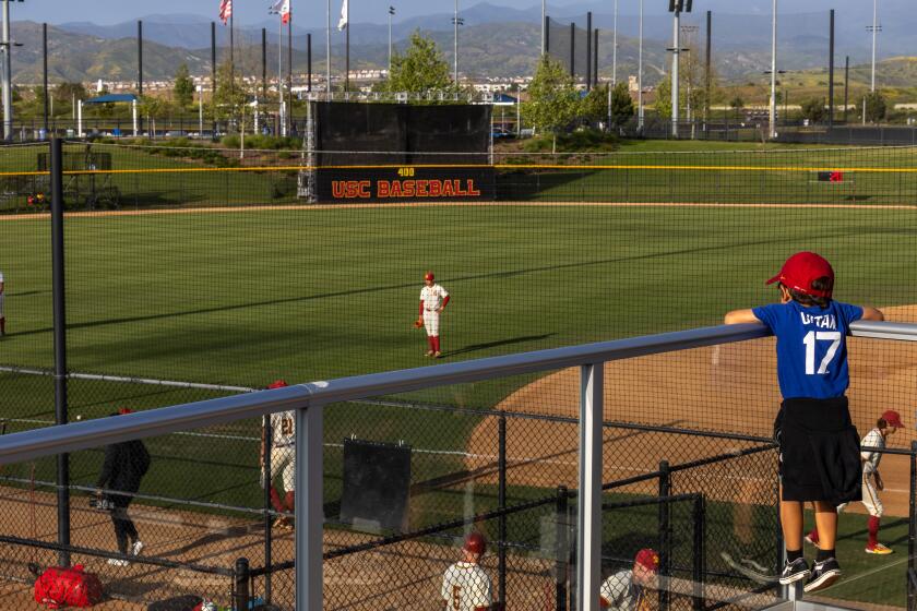 Irvine, CA - May 03: Tre Burkitt, 8, of Fountain Valley, watches the USC baseball team warm up before a game with Cal at the Great Park in Irvine Friday, May 3, 2024. The USC baseball team is having its on-campus stadium renovated this year and as a result, the Trojans have been forced to play their home games off campus, with the bulk of them being played in Irvine. Admission is free to these "home" games, but it's still far away from school. (Allen J. Schaben / Los Angeles Times)
