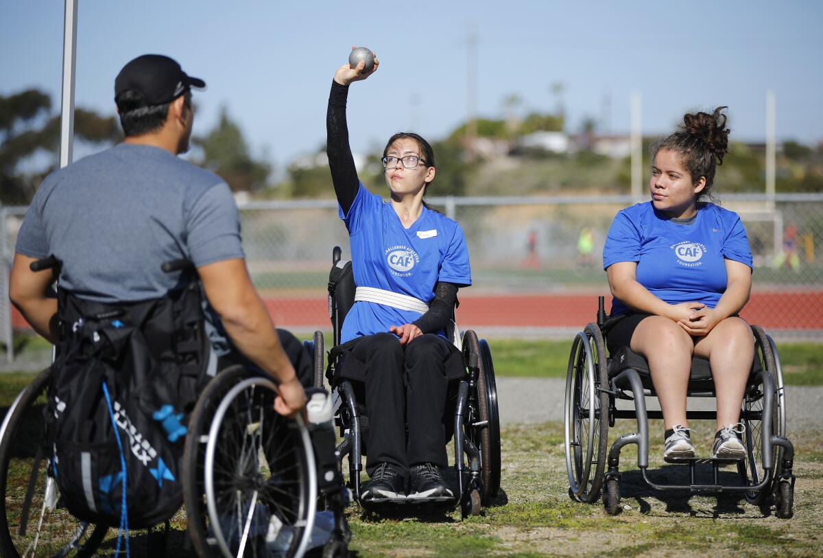 Paralympian Justin Phongsavanh, left, coaches students at a high school adaptive sports clinic in 2020.