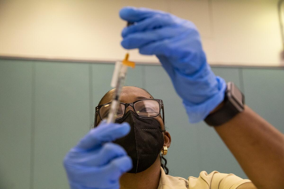 Registered nurse Marcia Reid prepares COVID-19 vaccines at a clinic at Balboa Sports Complex in Encino.