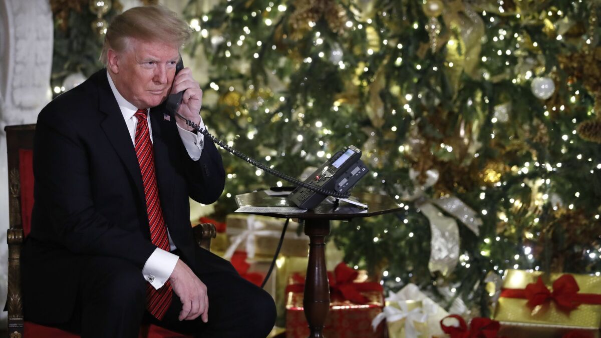 President Trump listens on the phone as he shares updates on Santa’s movements from the North American Aerospace Defense Command's Santa tracker on Christmas Eve.