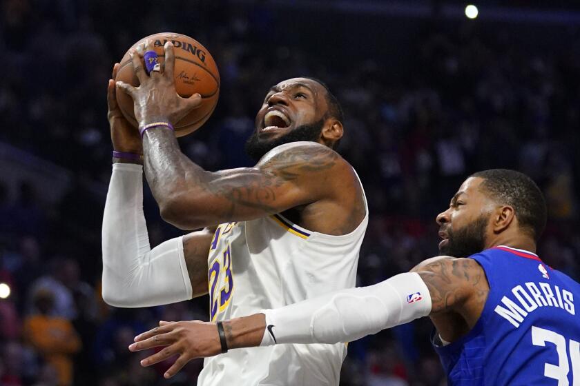 Los Angeles Lakers forward LeBron James, left, shoots as Los Angeles forward Marcus Morris Sr. defends during the second half of an NBA basketball game Sunday, March 8, 2020, in Los Angeles. The Lakers won 112-103. (AP Photo/Mark J. Terrill)