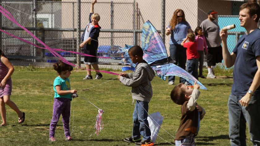 Children play with kites on the playground at Ocean Beach Elementary School. The San Diego Unified School District is facing $117 million in possible cuts. User Upload Caption: The Ocean Beach Kite Festival takes place at Dusty Rhodes Park.