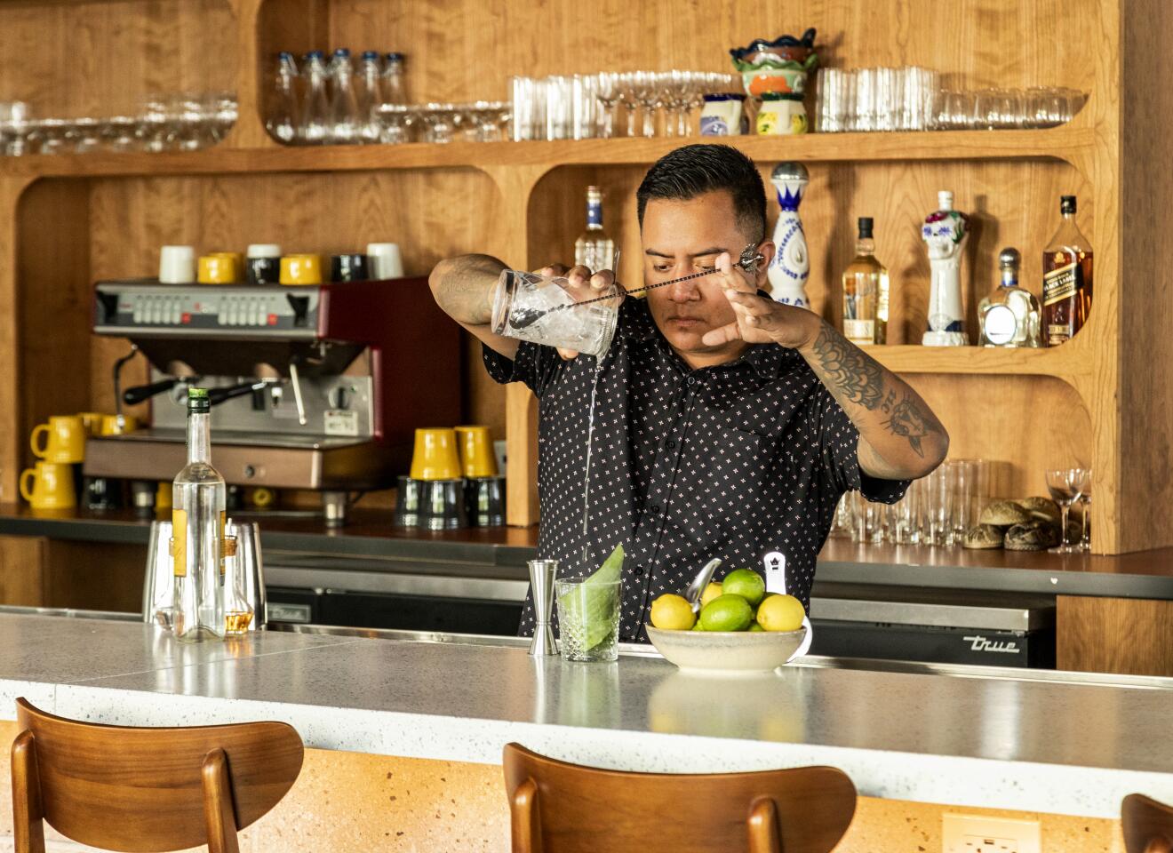 Mixologist Juan Martinez prepares a drink behind the bar at Socalo