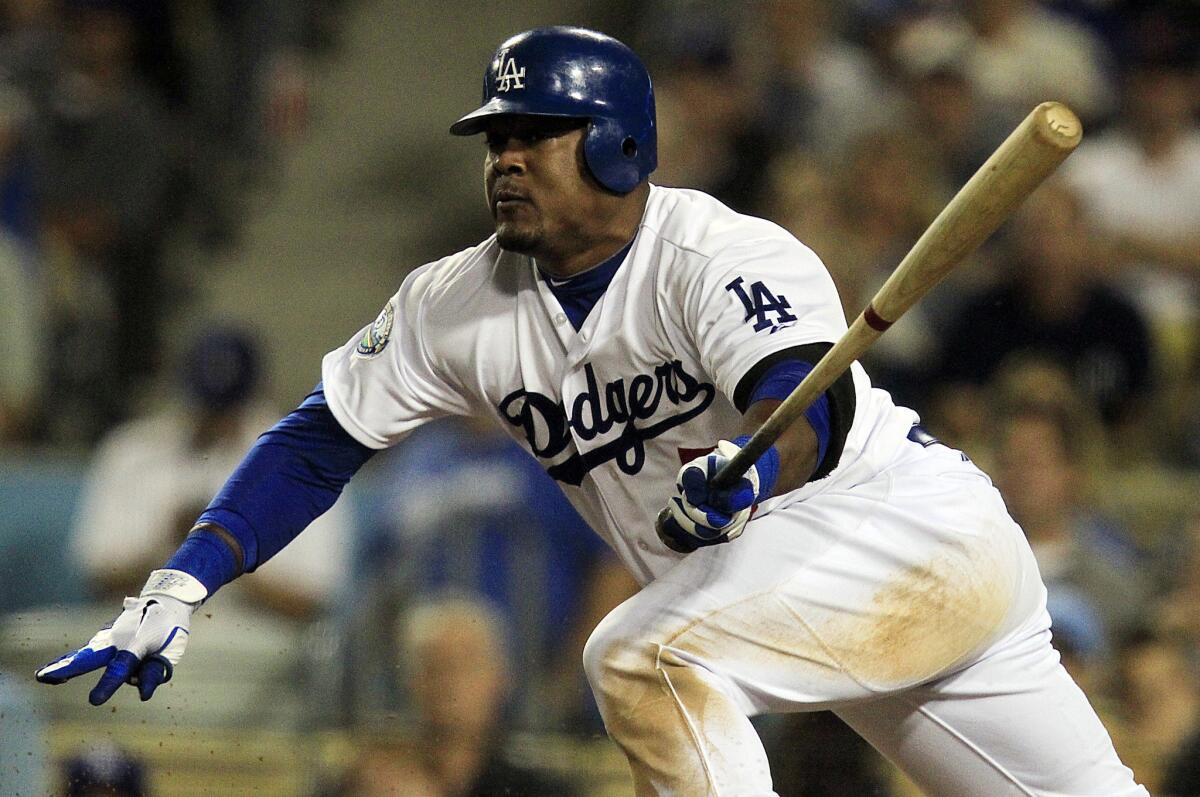 Dodgers infielder Juan Uribe breaks from the batter's box after hitting a run-scoring single against the Giants.