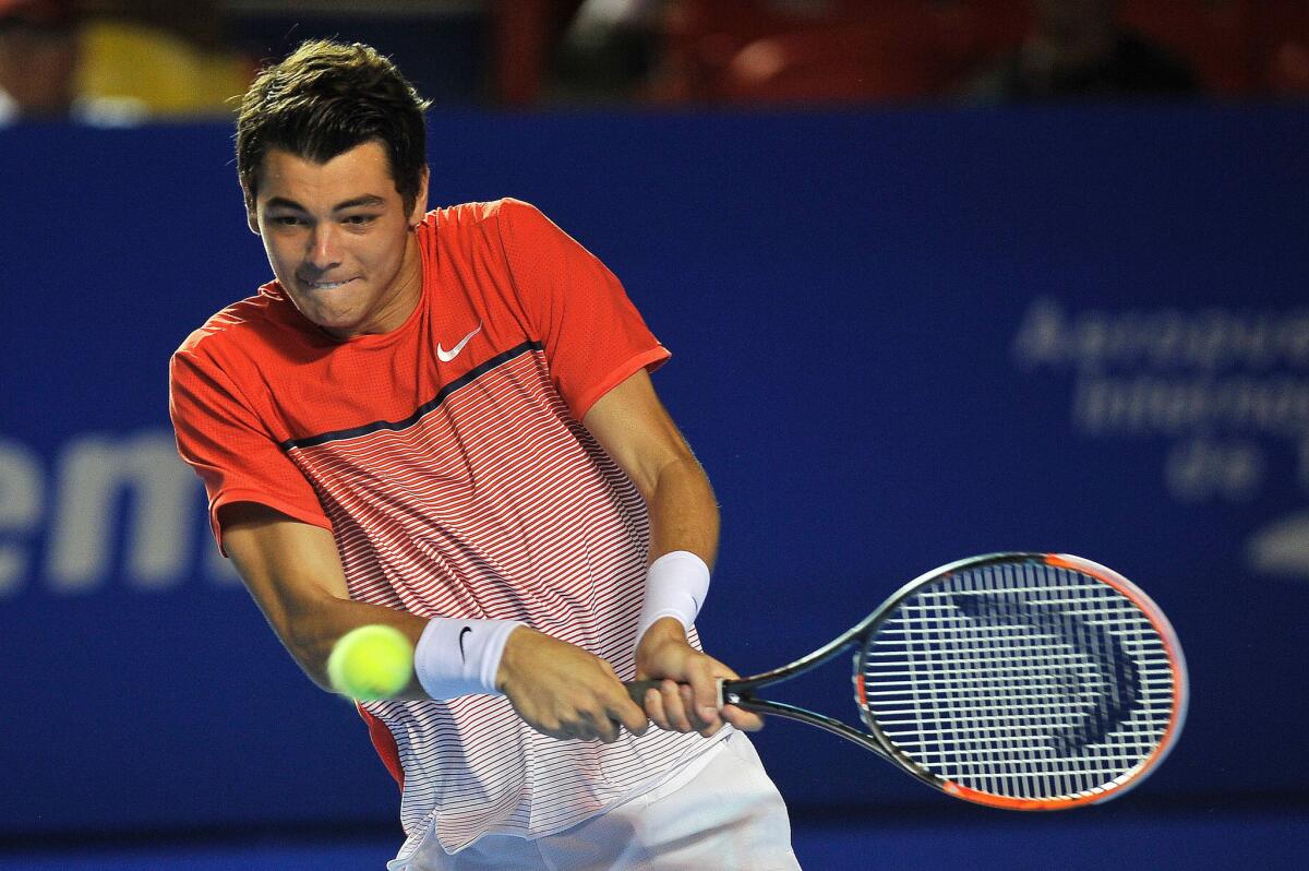 Taylor Fritz returns the ball with a backhand shot against Sam Querrey during their Mexico ATP Open match.