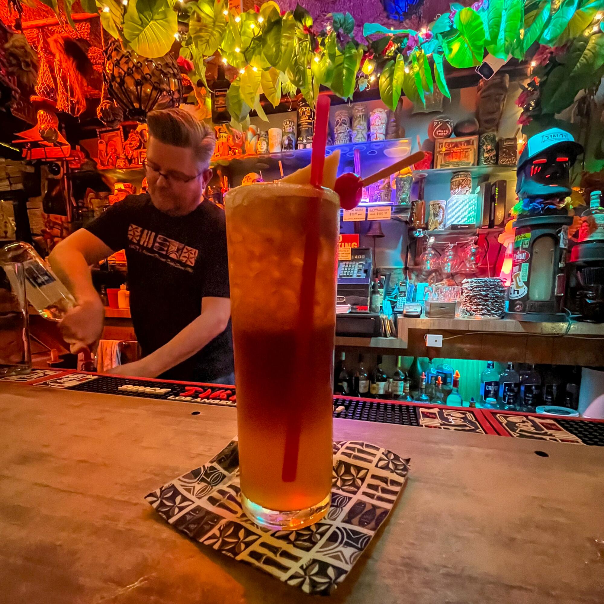 A bartender makes a drink at Tiki-Ti while another drink is on the bar.