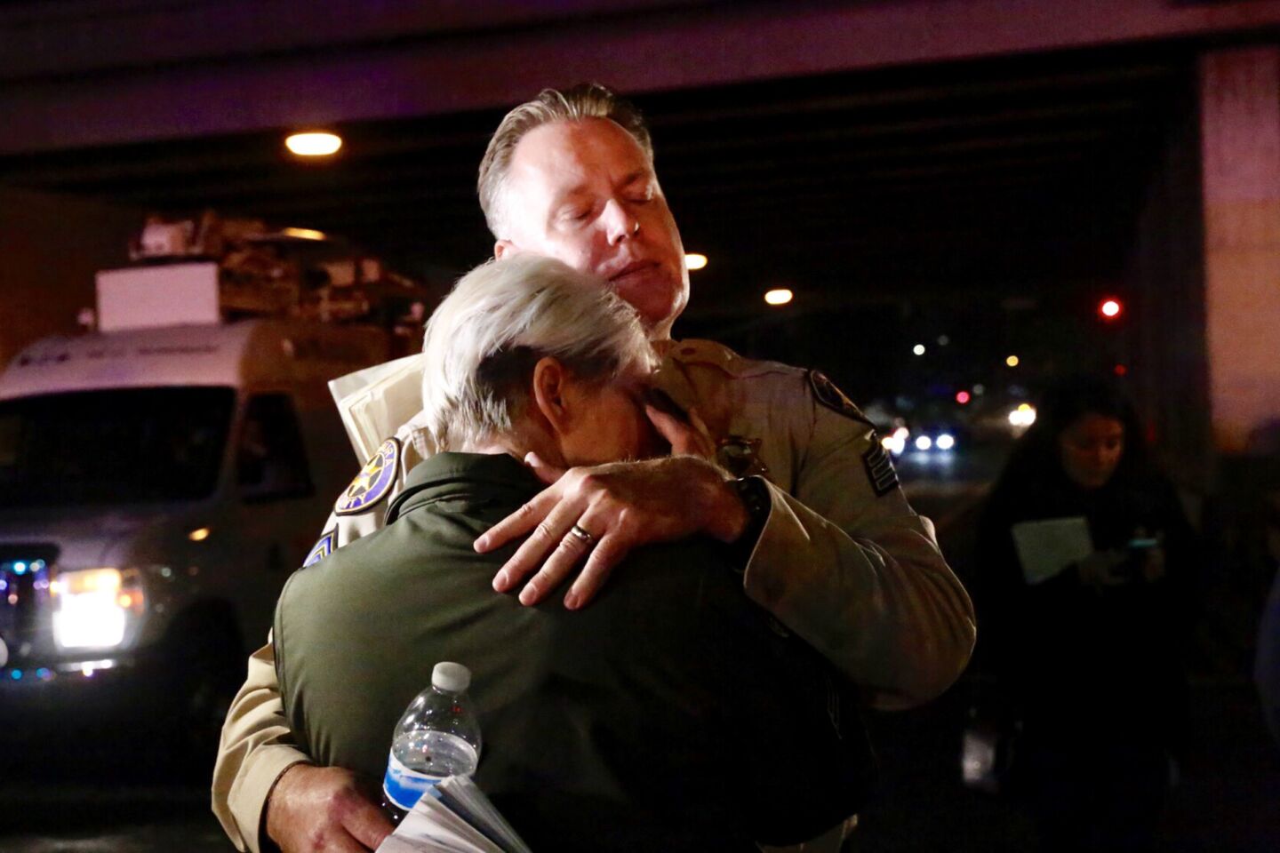 Ventura County sheriff's Sgt. Eric Buschow and Sgt. Julie Novak embrace outside the Borderline Bar & Grill after a gunman fatally shot 12 people, including a fellow deputy.