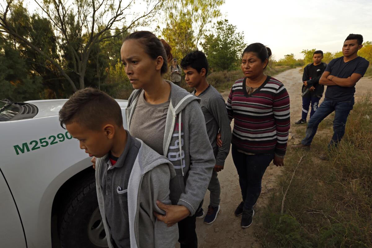 Migrants in McAllen, Texas, wait to be transported to a detention center.