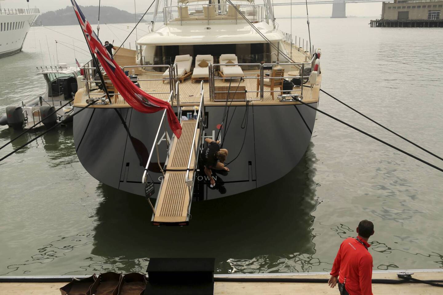 A crew member cleans the sailing yacht "Asahi," belonging to Oracle CEO Larry Ellison, at the America's Cup Center prior to the round robin one yacht races of the Luis Vuitton Cup challenger series in the 34th America's Cup in San Francisco