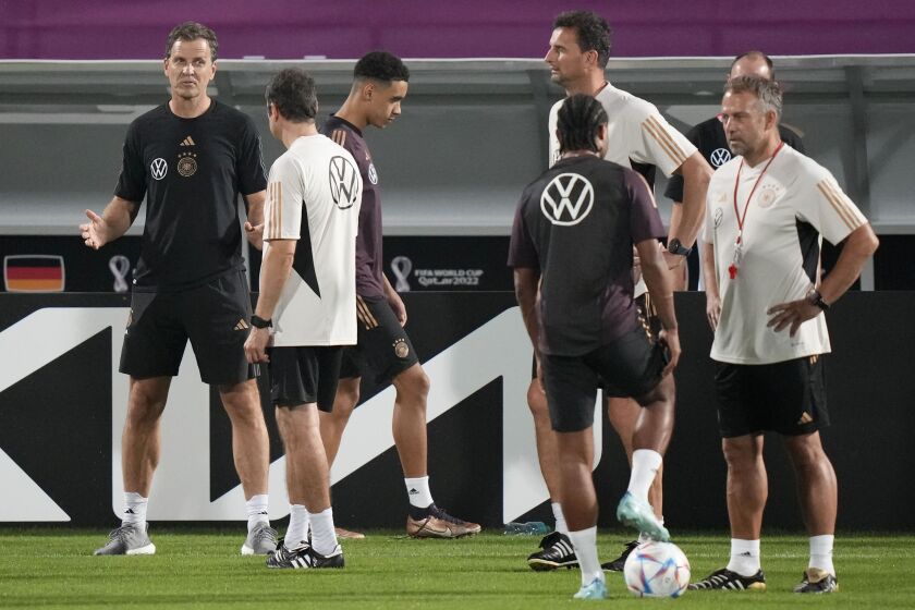 FILE - Germany's manager Oliver Bierhoff, left, talks to coaches besides head coach Hans Flick, right, prior to a training session at the Al-Shamal stadium on the eve of the group E World Cup soccer match between Germany and Costa Rica, in Al-Ruwais, Qatar, Tuesday, Nov. 29, 2022. Bierhoff is the first managerial casualty of Germany’s early World Cup exit after agreeing to resign as managing director of the country’s national soccer teams and academy. The German soccer federation said Monday, Dec. 5, 2022, that Bierhoff had agreed to prematurely end his contract. (AP Photo/Matthias Schrader, File)