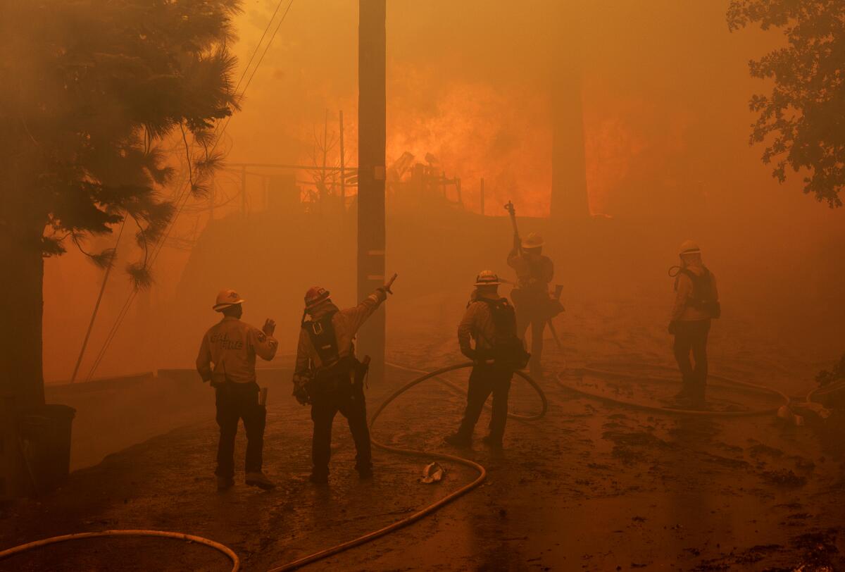 Firefighters watch flames engulf a home