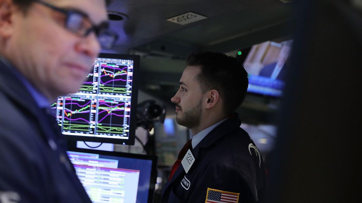 Healthcare and household goods companies fell after Johnson & Johnson and Procter & Gamble gave disappointing quarterly reports. Above, traders work on the floor of the New York Stock Exchange.