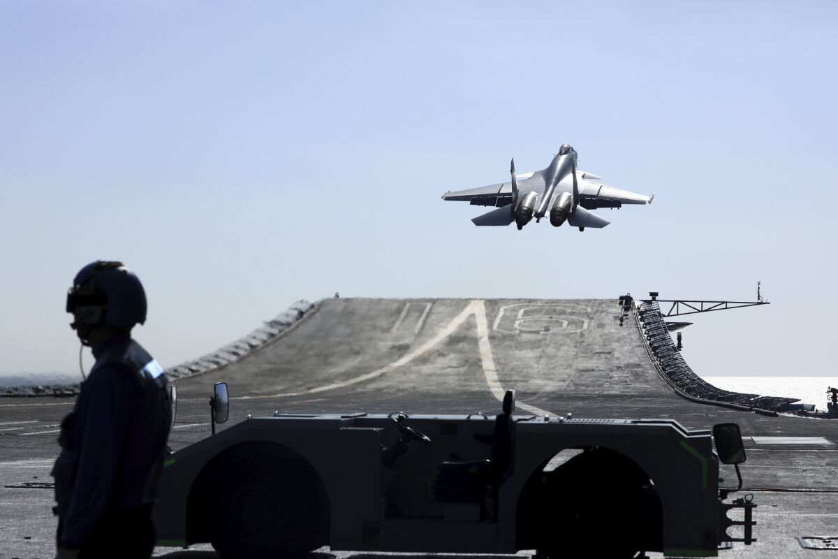 In this undated photo released on Dec. 31. 2021, by Xinhua News Agency, a carrier-based J-15 fighter jet takes off from the Chinese Navy's Liaoning aircraft-carrier during open-sea combat training in waters from the Yellow Sea to the East Sea and West Pacific. China's Liaoning aircraft carrier group has embarked on a "realistic combat" training mission in the Western Pacific, the Chinese navy said Tuesday, May 3, 2022. (Hu Shanmin/Xinhua via AP)