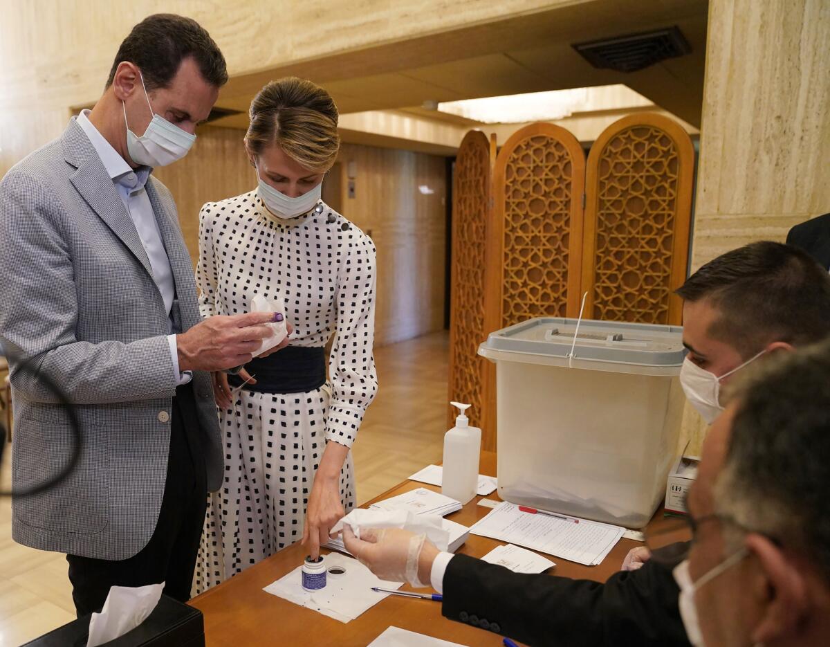 Syrian President Bashar Assad and wife Asma vote at a Damascus polling station in parliamentary elections last July.