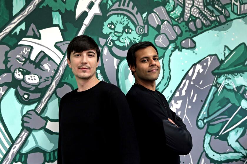 In this Wednesday, Dec. 2, 2015, photo, Robinhood co-founders Vlad Tenev, left, and Baiju Bhatt pose at company headquarters in Palo Alto, Calif. Robinhood is a stock brokerage that does not charge any commissions for its more than 1 million customers to buy and sell shares. "During the next 10 years, we are going to create an international company that will be like nothing the financial services industry has ever seen," says Bhatt. (AP Photo/Ben Margot)