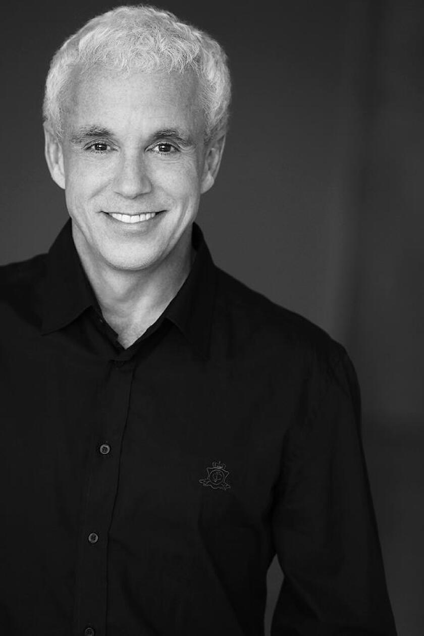 A portrait of a man in a black shirt.