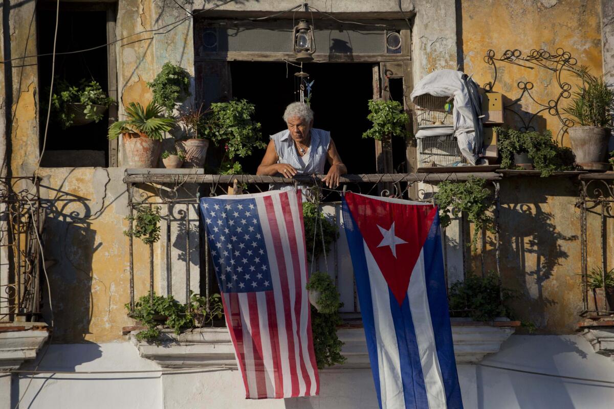 Javier Yanez stands on his Havana balcony decorated with U.S. and Cuban flags in 2014. American Airlines is launching weekly charter flights from Los Angeles to Havana.
