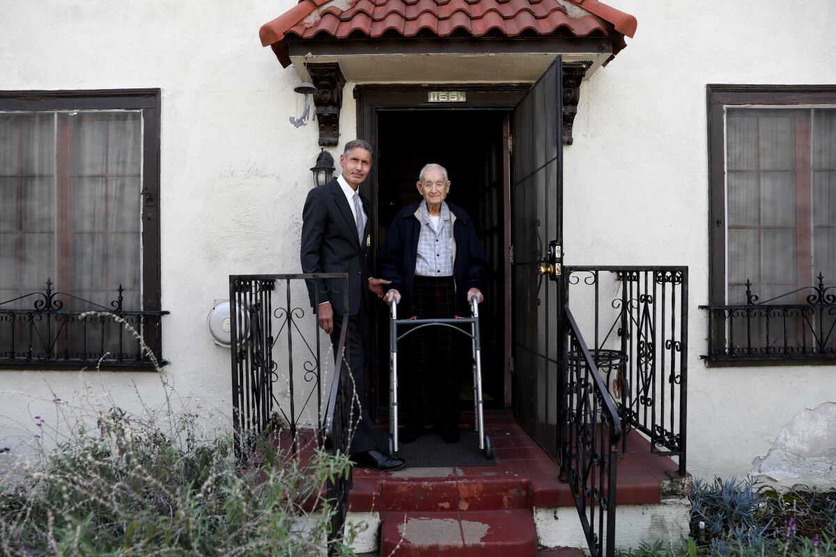 Two people outside the Rose Garden Court apartments in Los Angeles.