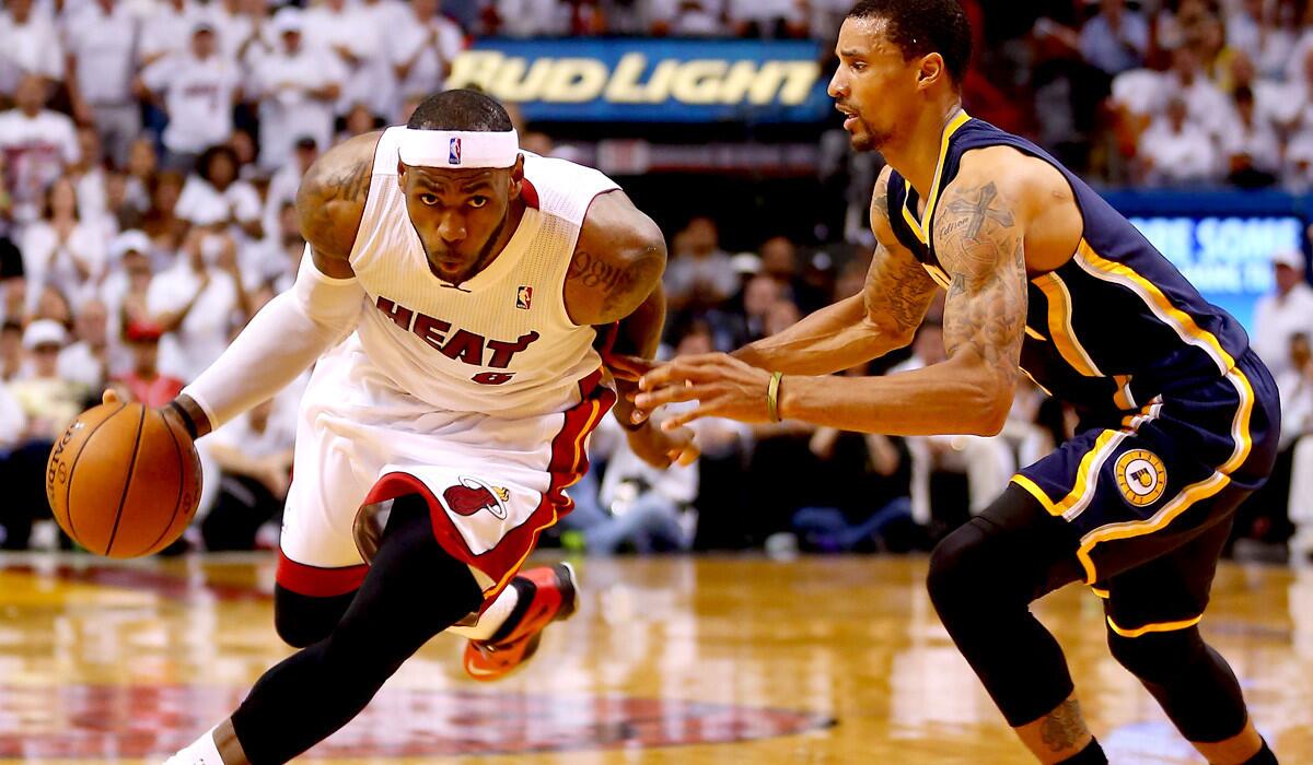 Heat forward LeBron James drives down the lane against Pacers guard George Hill in the first half of Game 4 on Monday night.