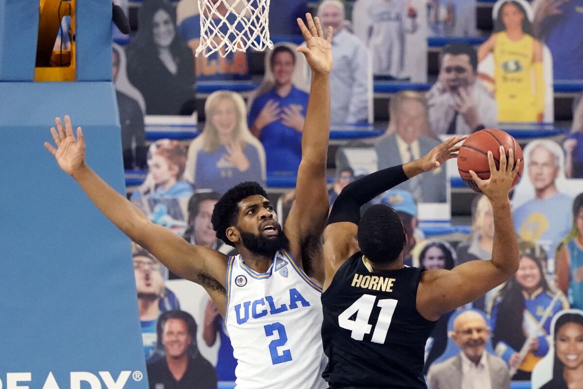 UCLA forward Cody Riley, left, defends on Colorado forward Jeriah Horne (41) during the second half of an NCAA college basketball game Saturday, Jan. 2, 2021, in Los Angeles. (AP Photo/Marcio Jose Sanchez)