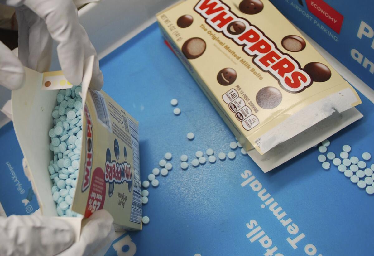Closeup of small blue pills in Whoppers boxes