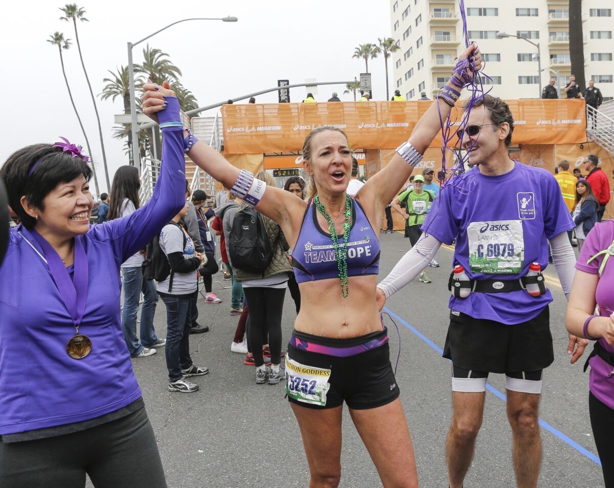 Julie Weiss, center, completed her 52nd marathon in 52 weeks. With her is fiance David Levine and six-month pancreatic cancer survivor Lupe Romero.