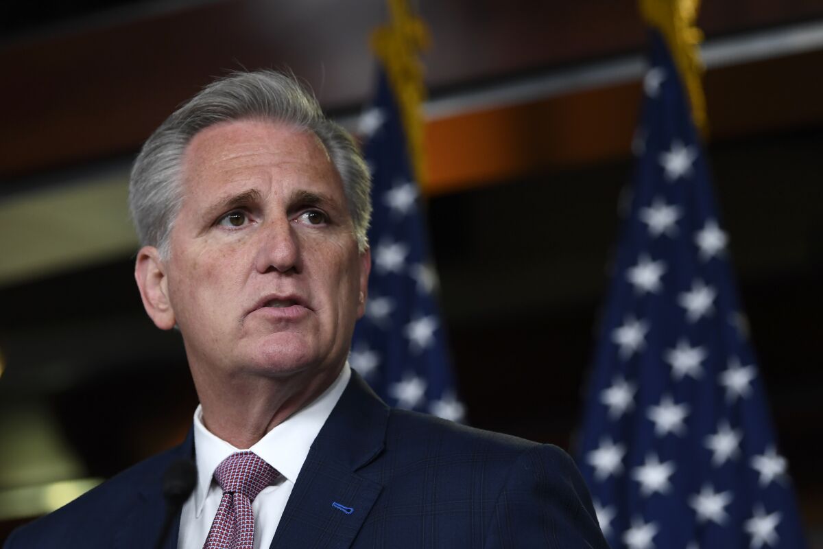 Kevin McCarthy with two American flags in the background. 