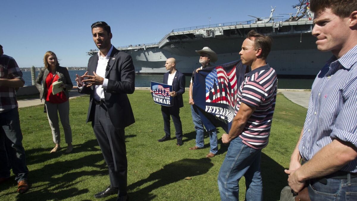 Ammar Campa-Najjar answers questions from the media after his opponent's father claimed the Democrat would be a security risk. Behind the candidate at center is retired Marine Brandon Coopersmith.