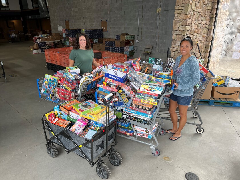 Sage Canyon Elementary PTA members Lauren Lash and Adriana Bade with items collected at the game/puzzle drive.