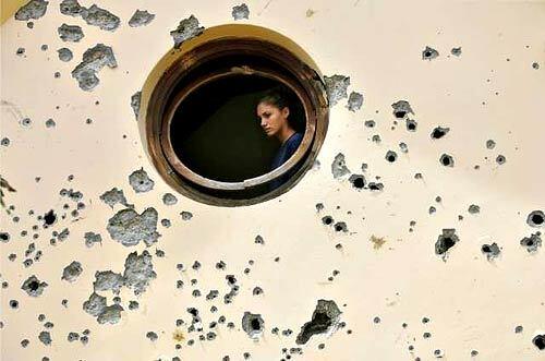 An Israeli woman looks at the damage inside a house that was directly hit by a rocket fired by Hezbollah guerrillas from neighboring Lebanon in the northern Israeli town of Carmiel Saturday, July 15.