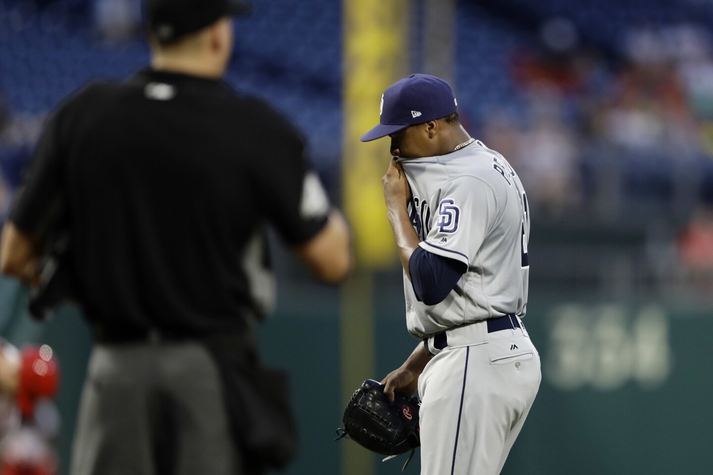 San Diego Padres starting pitcher Luis Perdomo, right, wipes his face as he walks to the dugout after being pulled during the seventh inning of the second baseball game of a doubleheader against the Philadelphia Phillies, Sunday, July 22, 2018, in Philadelphia. (AP Photo/Matt Slocum)