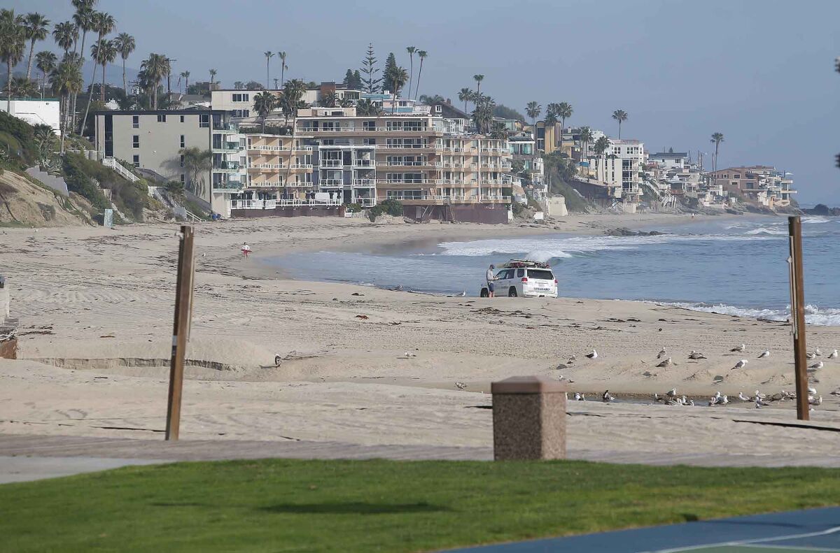 The grass, boardwalk and sand remain empty as only a lifeguard occupied Main Beach on Sunday as Laguna Beach city beaches remained closed due the COVID-19 pandemic.