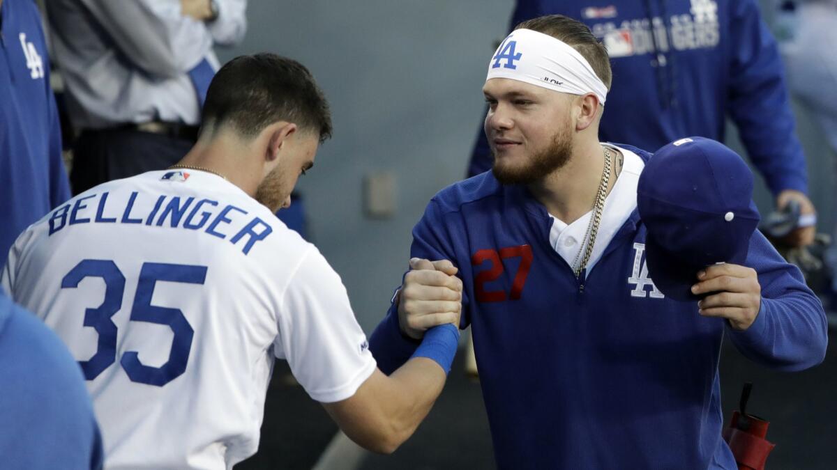 Dodgers' Alex Verdugo, right, shakes hands with teammate Cody Bellinger before the start of the game against the Pittsburgh Pirates on Friday at Dodger Stadium.