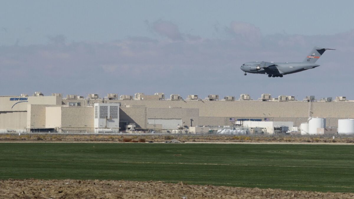 A Boeing C-17 Globemaster III lands at Palmdale Regional Airport during recent exercise flights. Northrop Grumman (background) was awarded the new B-21 bomber contract in 2015.