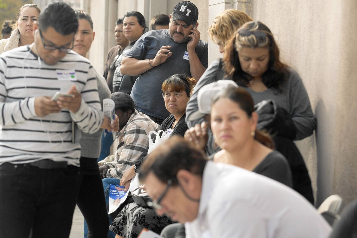 People wait in line to get health insurance at an event that invited the public to enroll in Medi-Cal and Covered California. A federal incentive for doctors to treat the low-income expires Jan. 1.